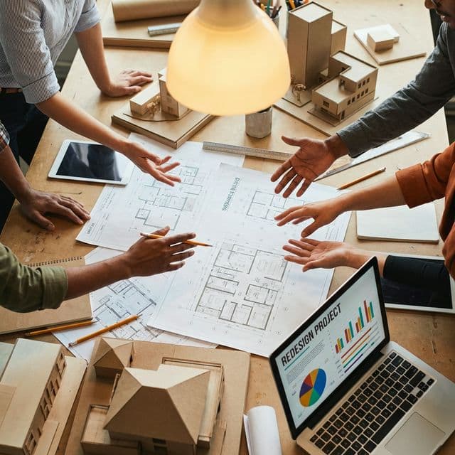 Collaborative workshop with blueprints, models, and data visualisations